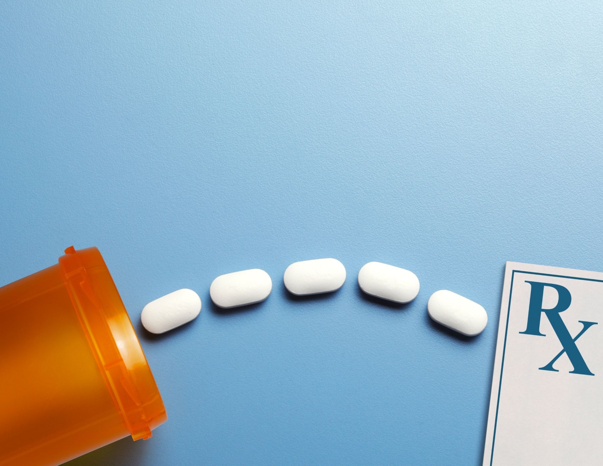 Assorted SSRIs pills on a blue surface